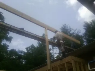 Carpenter setting a ridge beam over a new addition frame — Ice Dam Removal by Roofing Brothers in Tioga